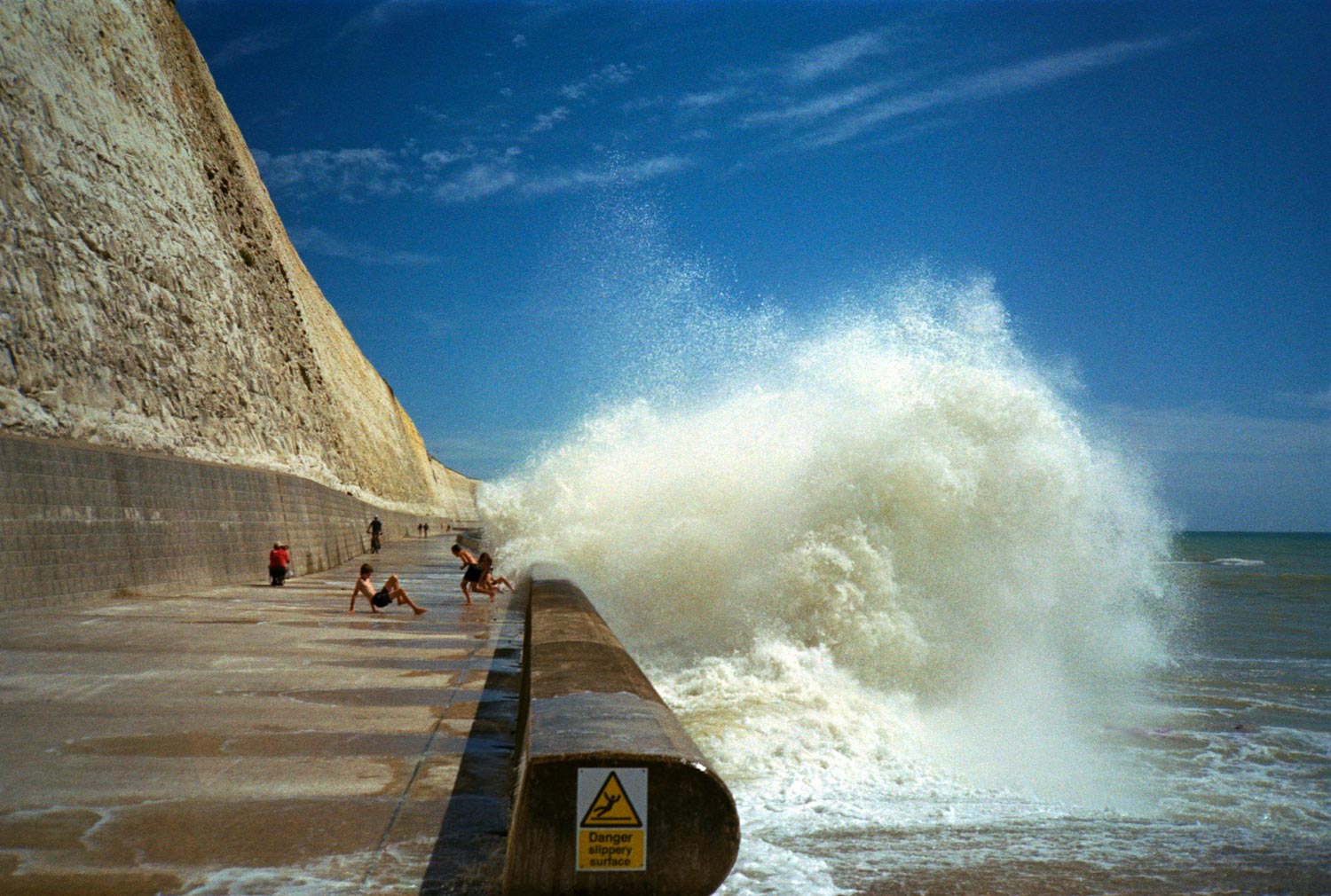 kids playing in the open waves, seafront, peacehaven promenade.
