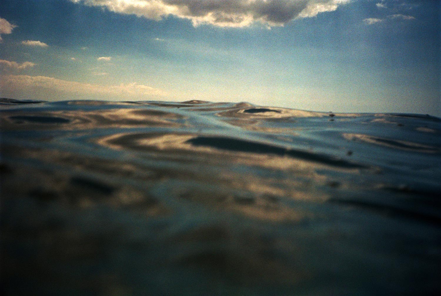 Speed boat on the open sea at sunset, analogue photography.