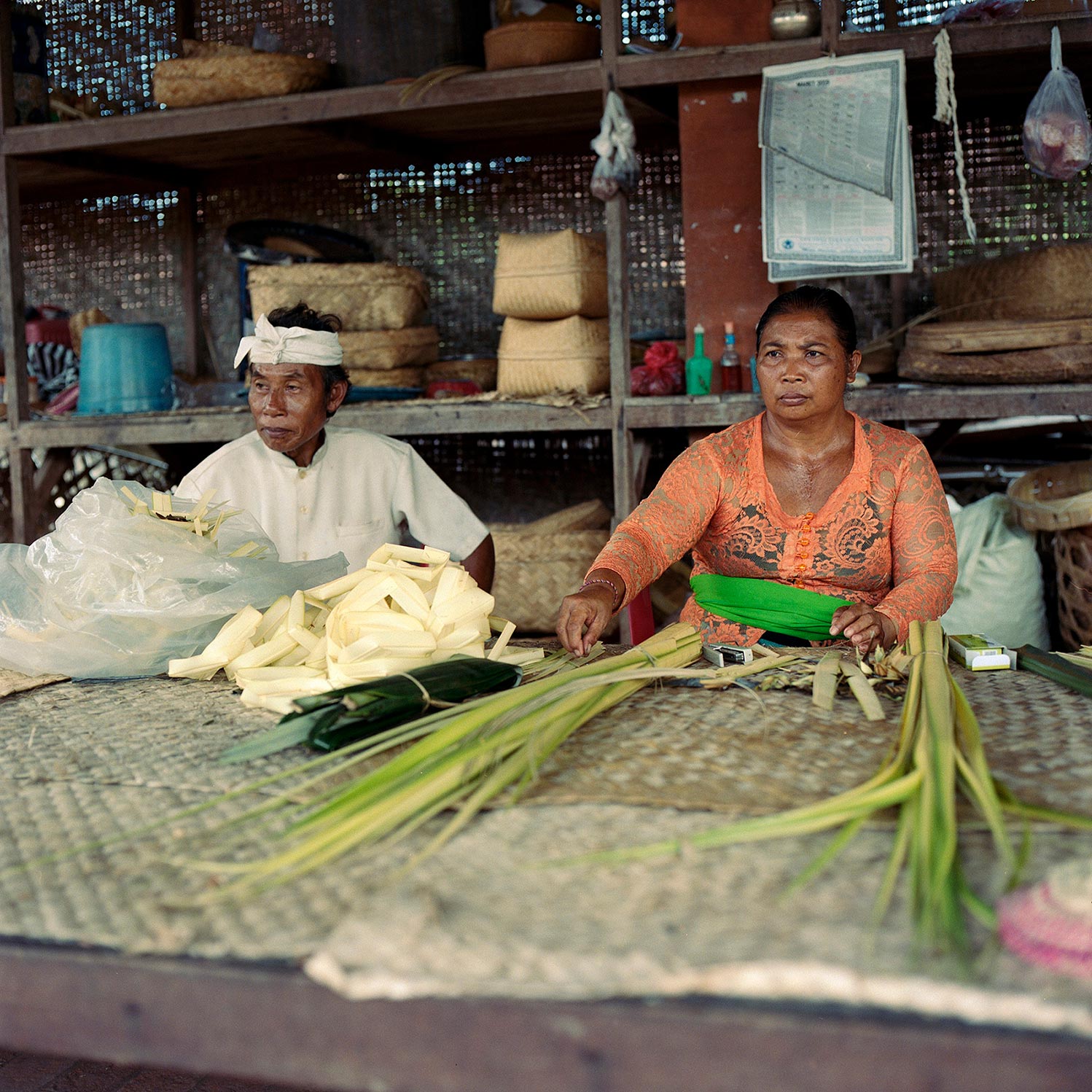 Wife and husband making Canang Sari Offerings for local festival.