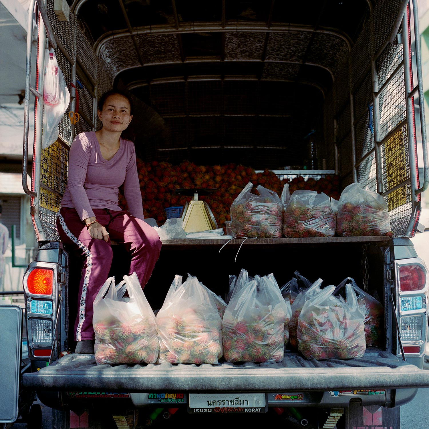 Woman selling Rambutan fruit from the back of a van, near China Town, Bangkok.