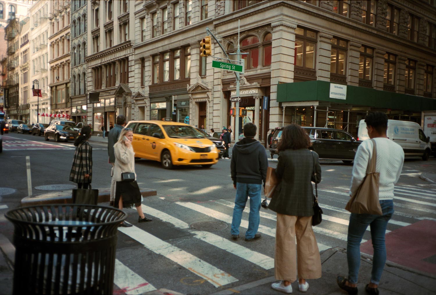 people crossing the crosswalk at Spring Street, Manhattan. 