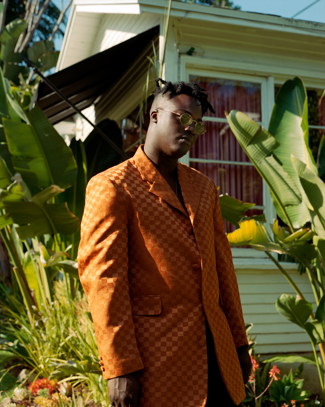 Biploar Sunshine, Musician, artist at home in his garden wearing orange checkboard suit jacket, Los Angeles.