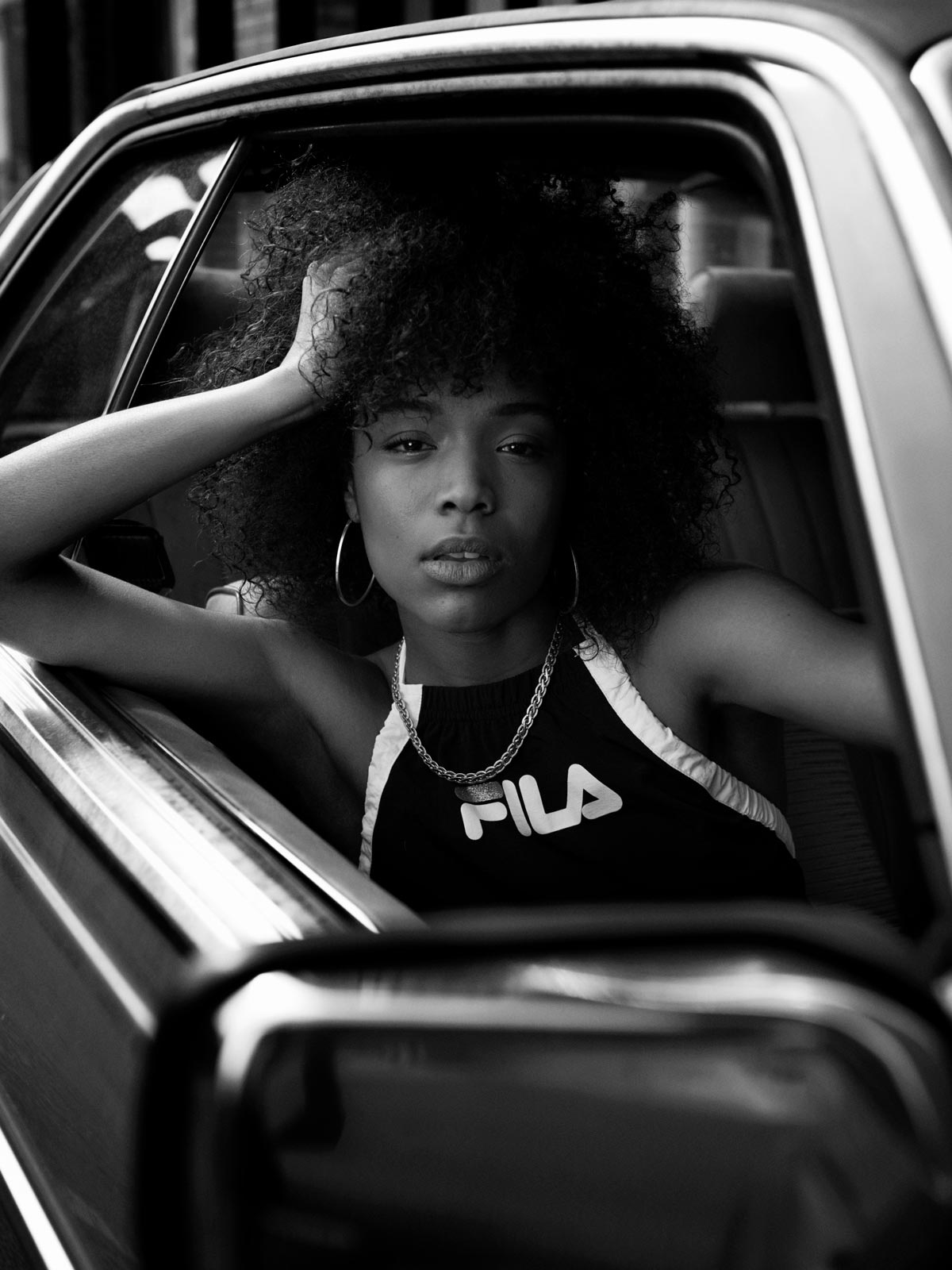 Woman posing in a car in Lodnon black and white photo, Fila UK SS18.