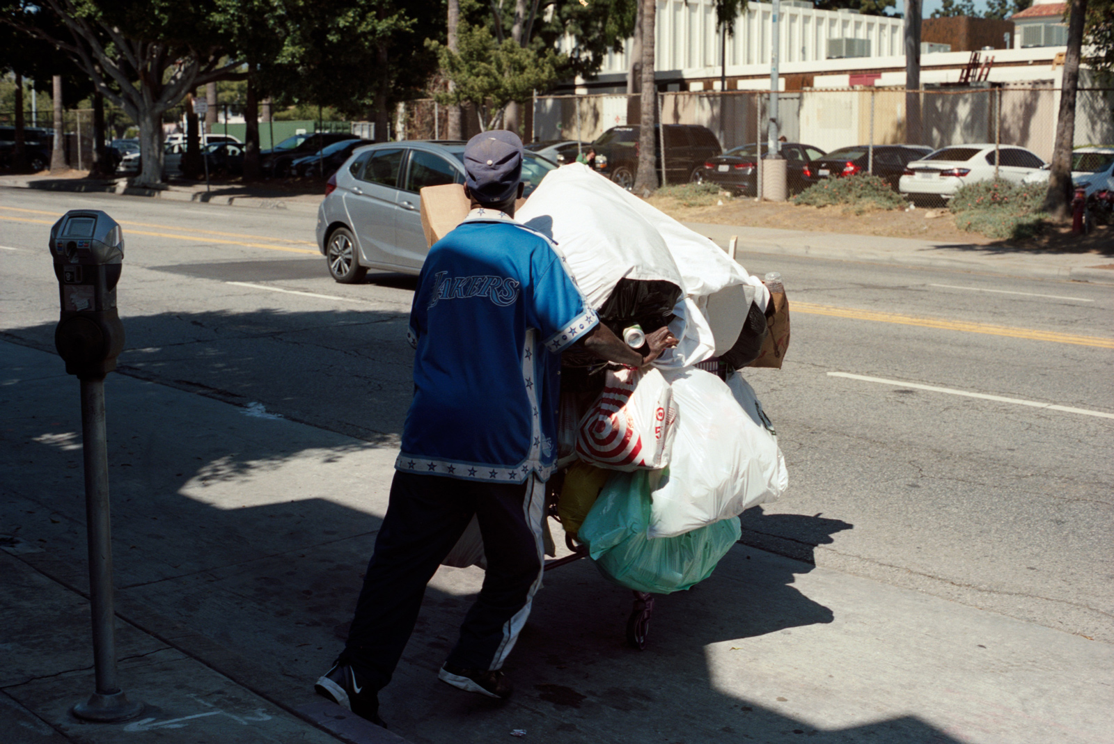 American man moving his worldly possessions in a trolley, street Photography